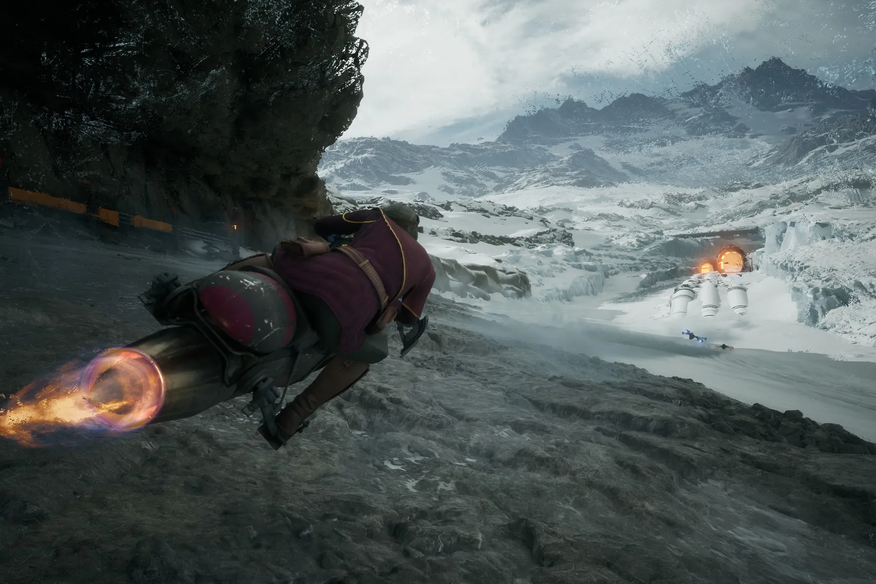 A speeder bike rider races along a snowy mountain course behind other racers.